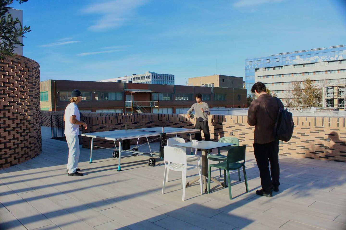 Personas trabajando y socializando en una terraza de coworking y coliving en Barcelona.